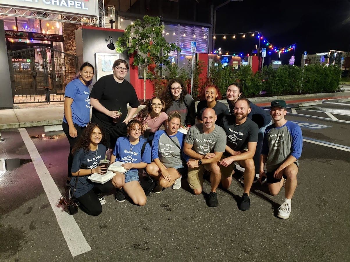 The shop team posing together outdoors at night