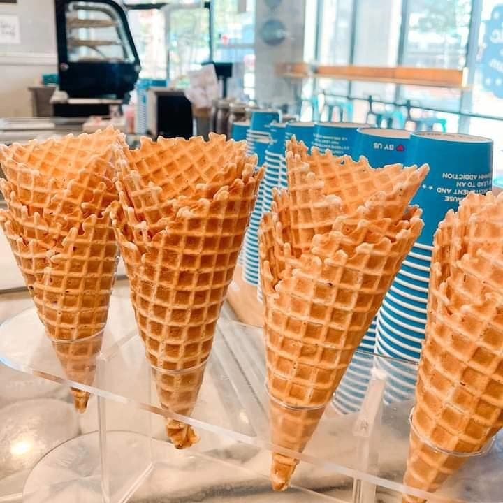 Fresh waffle cones standing in a display rack on the shop counter